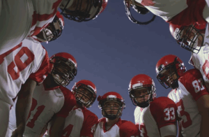 american football team huddle before play
