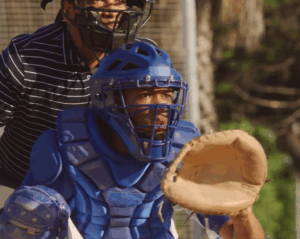 baseball catcher in blue gear ready to receive pitch