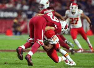 nfl football player tackling opponent during game
