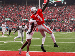 ohio state wide receiver leaping to catch football against indiana defender