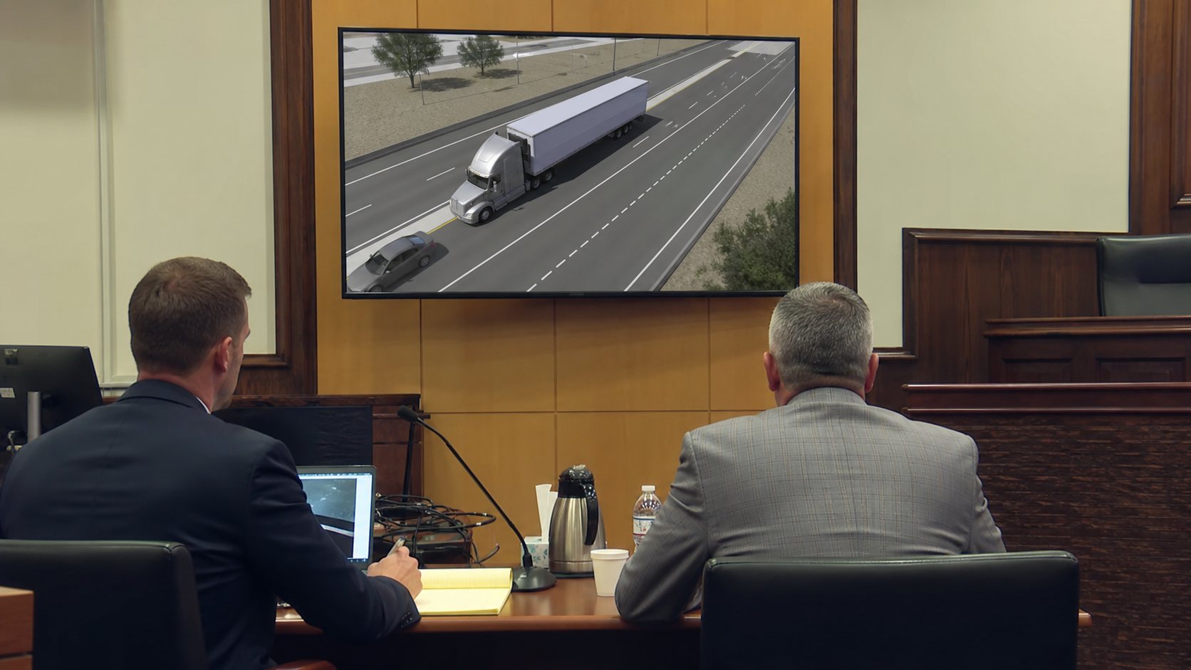 Truck accident reconstruction animation displayed in a modern courtroom