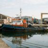 Commercial workboat moored beside a shipyard quay at daylight