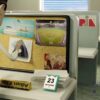 Animated office scene with a character pinning photos on a bulletin board a desk calendar and a nameplate in view