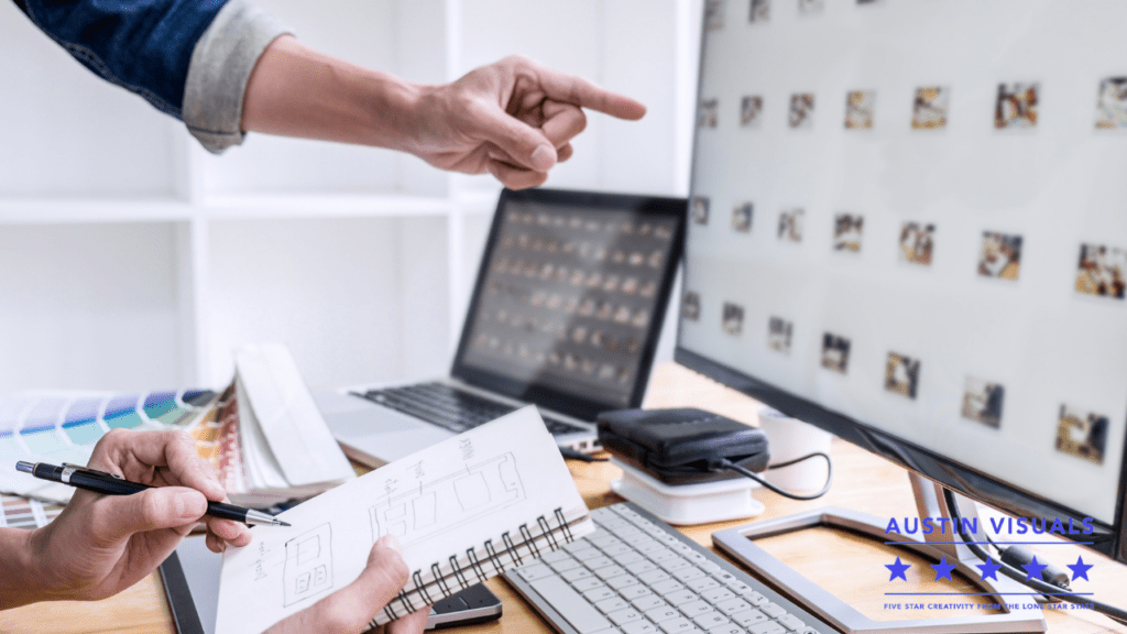 art director pointing the pictures or videos that will be used for their next project that is taken notes by an associate