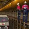 workers in safety gear inspecting underground pipeline with vehicles in industrial tunnel d animation rendering